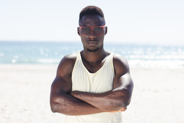 Obraz premium Young African American man stands confidently on the beach