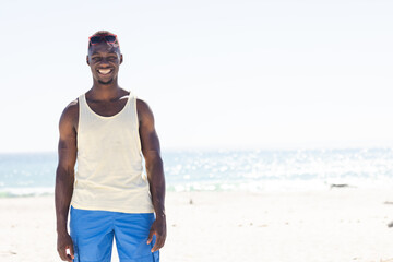 Young African American man enjoys a sunny beach day, with copy space unaltered