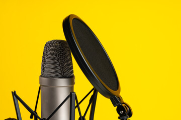 Professional microphone stand over yellow studio background