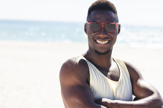 Naklejki Young African American man enjoys the sun at the beach