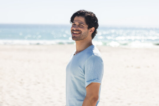 Young biracial man enjoys a sunny day at the beach - Powered by Adobe
