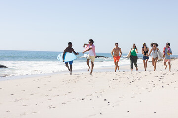 Diverse group of friends enjoy a day at the beach with copy space