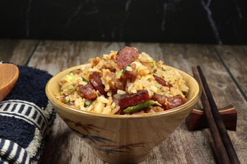 Stirred rice with Chinese pork sausage, egg and spring onion serving in the bowl. Famous rice menu in Asian restaurant. Classic breakfast menu concept.