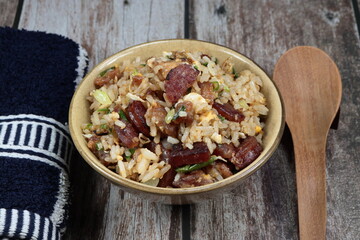 Stirred rice with Chinese pork sausage, egg and spring onion serving in the bowl. Famous rice menu in Asian restaurant. Classic breakfast menu concept.