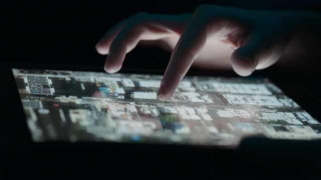 Person zooming in on a city street using a 3D map on a tablet. Close up, slow motion. 
