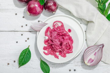 Jar with tasty pickled onions on black table. Cutlery, served meal ready to eat, trendy stand