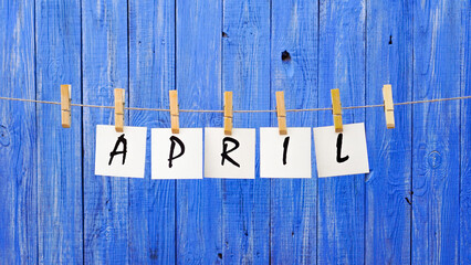 April word. April month. The inscription on the cards on a wooden blue background. Spring, warming. Spring sunny days. Calendar.	