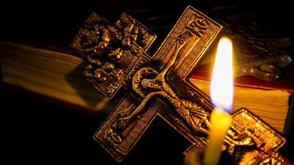 Christian cross and Bible. Burning candle. The concept of a person's faith in God.	