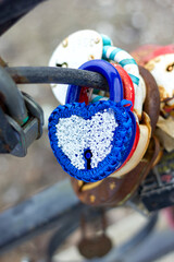 wedding souvenir tradition padlock decorated with ribbons closed on the fence in the park