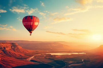 Hot air balloon flies at sunset over hills and mountain rivers through the sunlight