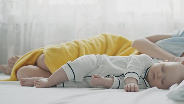 Sleep infant cover with yellow blanket on white bed, serene slumber, soft focus, cozy home setting. Cute Baby Rest, peaceful nap, comfort cloth, tranquil domestic scene, dream time, calm environment.