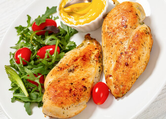 fried chicken breasts with green salad on plate