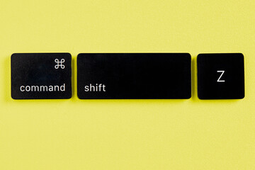 The command key, shift key and Z key are removed from a keyboard with orange background