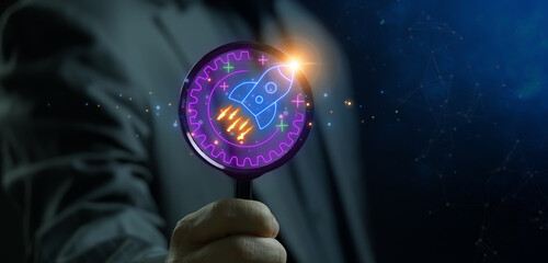 Magnify glass focus on neon illustration Gear with rocket take off. The concept for launching and...