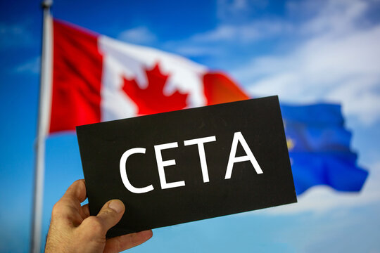 Schild mit der Aufschrift CETA vor den Flaggen von Kanada und der Europäischen Union. Die Abkürzung CETA steht für ein Freihandelsabkommen zwischen den beiden Partnern