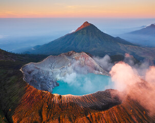 Aerial view of Kawah Ijen volcano in the clouds with beautiful sunrise