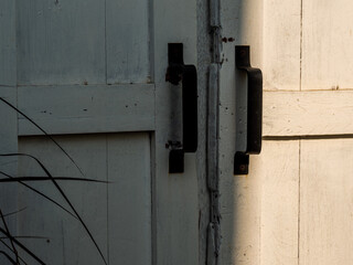 An old white wooden door with a simple bent iron handle - 736877884