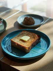french toast with piece of butter on a blue plate