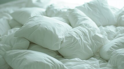 a pile of white pillows sitting on top of a bed covered in a white comforter and pillows on top of a bed.