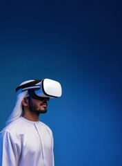 Middle Eastern Muslim Young Adult Man Using VR Headset, Enjoying Virtual Reality Experience on Flat Blue Background with Studio Lighting. Vertical Photo Portrait with Empty Copy Space