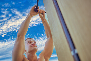 Man tightening nut on compression fitting of external water supply system for eliminating leakage,...