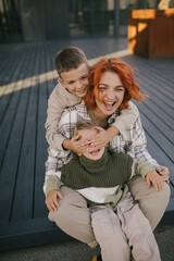 Happy mother and her two sons having fun spending time together outdoors.