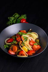 Korean food. Tofu, chicken meat with vegetables. on a black wooden background