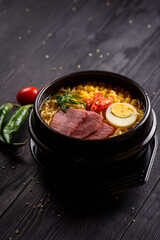 Korean food. Ramen with smoked beef. on a black wooden background