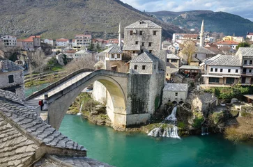 Photo sur Plexiglas Stari Most View of the Old Bridge in Mostar city in Bosnia and Herzegovina. Neretva river. Unesco World Heritage Site. People walking over the bridge.
