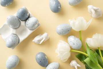 Easter aesthetic display: top view pattern image of ash grey eggs in a custom ceramic bowl, bunnies decor, bouquet of tulips on a pastel beige canvas, leaving margin for script
