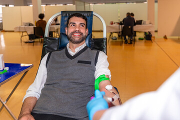 Altruist smiling man donating blood in a pavilion