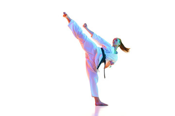 Master of Kung Fu, fighter show high kick pose in neon light, filter against over white background. Concept of sport, recreation, art, hobby, culture. Copy space for ad, text.