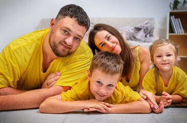 Portrait of a cute family with two children on the floor