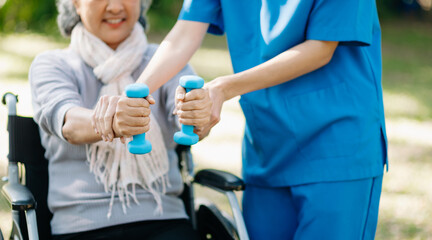 Asian physiotherapist helping elderly woman patient stretching arm during exercise correct with...