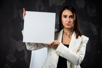 A business woman holds an empty sign in front of the camera.