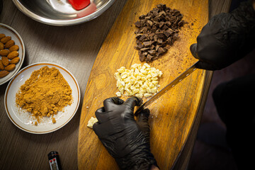Woman cooking tasty melted chocolate on table in kitchen.