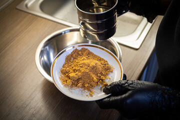 Woman cooking tasty melted chocolate on table in kitchen.
