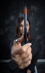 Portrait of a female artist, with brushes in her hands..