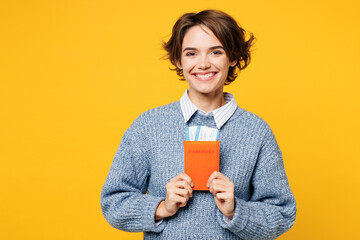 Traveler happy woman wear grey casual clothes hold passport ticket isolated on plain yellow...