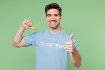 Young man in blue t-shirt title volunteer show thumb up like gesture point finger on himself...