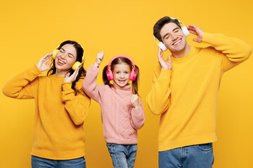Young happy cool parents mom dad with child kid girl 7-8 years old wear pink sweater casual clothes...