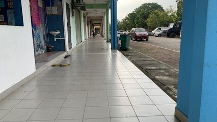 Pedestrian lane in front of the row of shops .