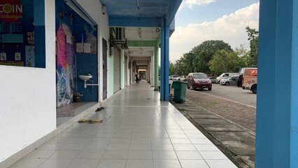 Pedestrian lane in front of the row of shops .