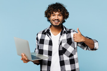 Young Indian IT man wears shirt white t-shirt casual clothes hold use work on laptop pc computer...