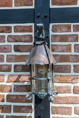 Forged iron street lamp on brick wall selective focus closeup - 736954647