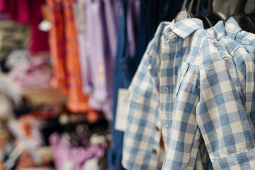 Children clothes hanging on hangers in the shop