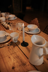 Table Setting in A Rustic Modern Cabin. White Set of Dishes on a wooden table.