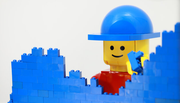 Hong Kong -February 15 2024: giant man build a brick wall piece by piece