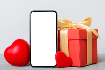 mobile phone with blank screen on colored background with hearts, calendar and gift box, valentine day concept perspertive view flat lay