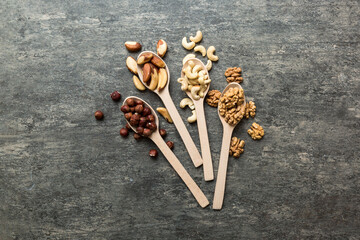 mixed nuts in white wooden spoon. Mix of various nuts on colored background. pistachios, cashews, walnuts, hazelnuts, peanuts and brazil nuts